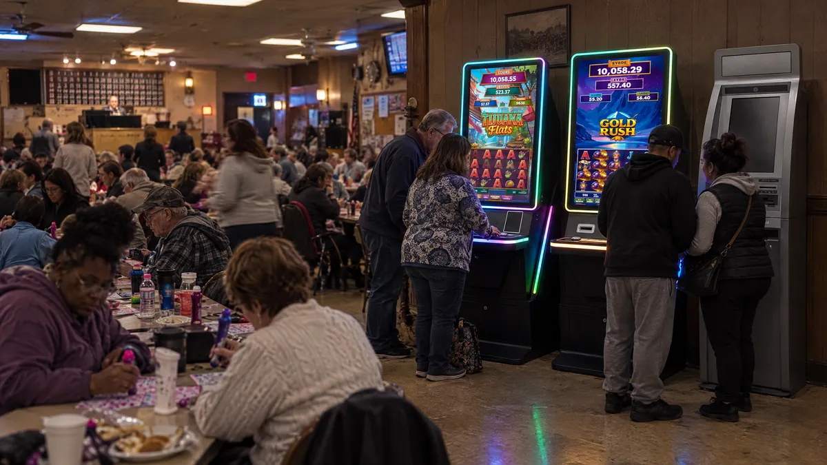 Four Foxfire cabinets and a payout kiosk along the wall of a bingo hall, with players at the machines and a crowd at the bingo tables behind them.